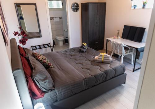 een slaapkamer met een groot bed, een bureau en een computer bij Villa Lory in Agrigento