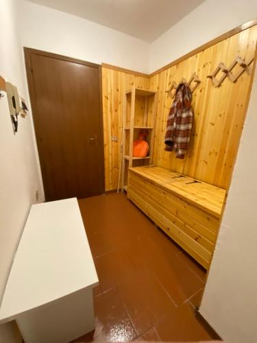 Zimmer mit einem Bett und einer Holzwand in der Unterkunft Perla alpina in Abetone