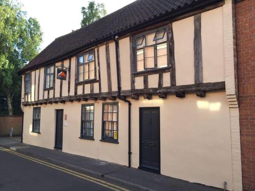 een wit en zwart gebouw met een zwarte deur bij No. 82 Grade II Listed Norwich City Centre Flat in Norwich