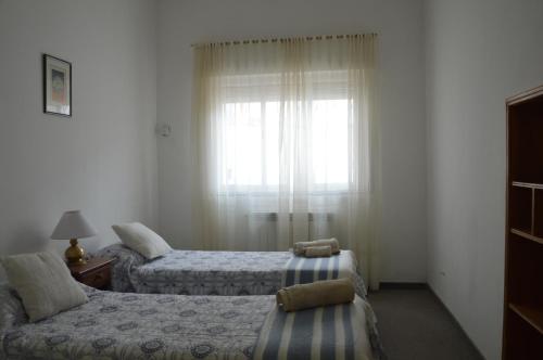 2 Betten in einem Zimmer mit Fenster in der Unterkunft Espacio de la Patagonia in Comodoro Rivadavia