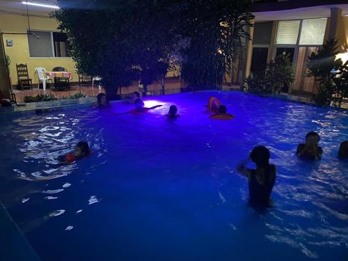 a group of people in a swimming pool at night at Hotel Del Valle in El Naranjo