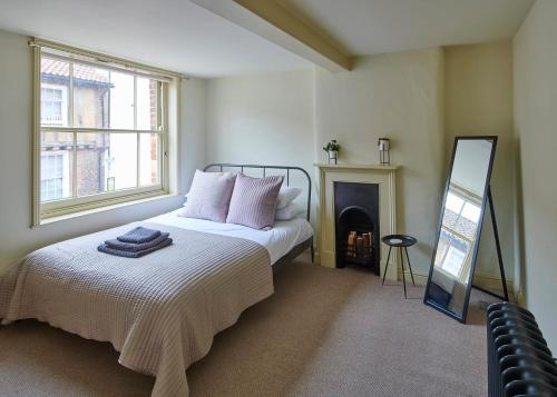 a bedroom with a bed with a fireplace and a mirror at Studio 2 - Central Location Sleeps 4 in Norwich