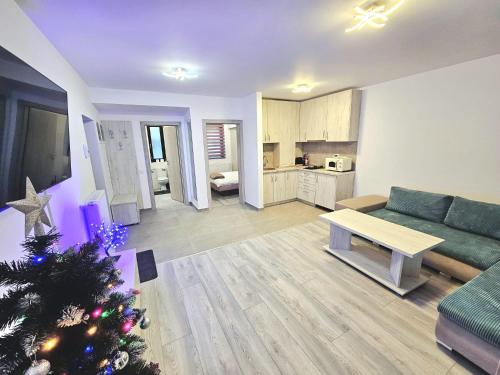 una sala de estar con un árbol de Navidad y un sofá en Snow Apartament en Buşteni