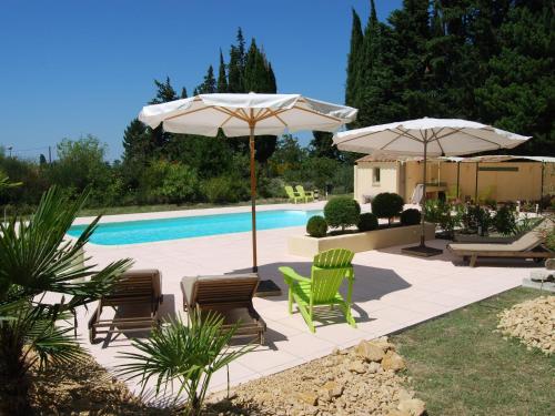 une terrasse avec des chaises et des parasols ainsi qu'une piscine dans l'établissement Beautiful appartment with pool in Provence, à Valréas