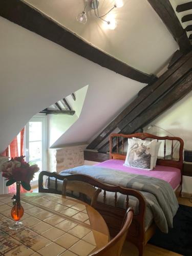 une chambre avec un lit dans un grenier dans l'établissement Appartement Héritage - 1 chambre 4 personnes, à Hargeville