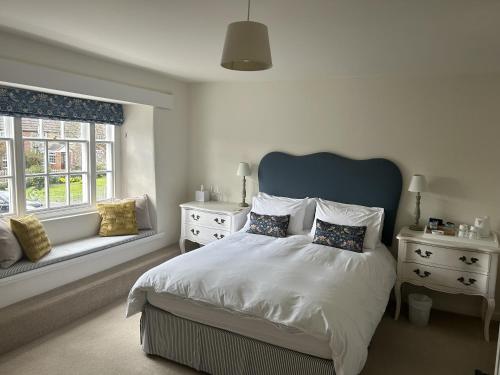 um quarto com uma cama grande e 2 janelas em The Heritage Bed and Breakfast em Weymouth