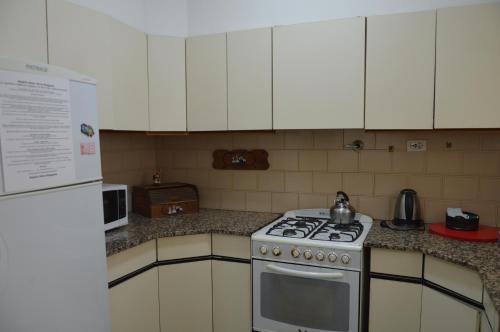 a kitchen with a stove and white cabinets at Espacio de la Patagonia in Comodoro Rivadavia