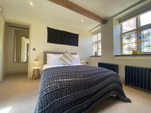 a bedroom with a bed with a black and white blanket at Studio 4- 6 Norwich City Centre Apartment in Norwich