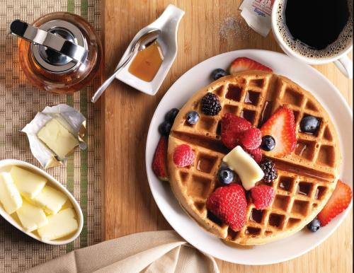 a plate of waffles with strawberries and blueberries at Home2 Suites By Hilton Winter Garden in Orlando