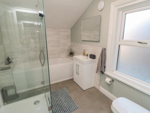 a bathroom with a shower and a sink and a toilet at Bay House in Bridlington