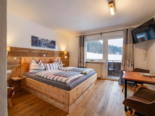 a bedroom with a bed and a large window at Berghof Haselsberger in Sankt Johann in Tirol