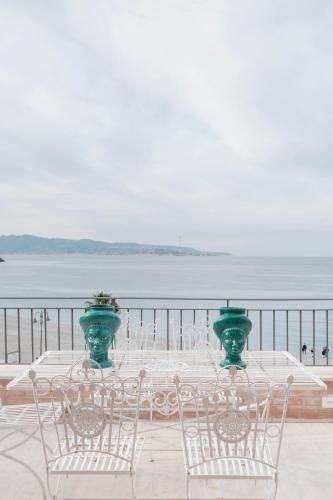a table and chairs with a view of the water at La balza di Scilla in Scilla