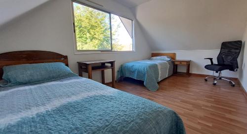 1 dormitorio con 2 camas, silla y ventana en 2 personas, desayuno, gran ubicación, en Osorno