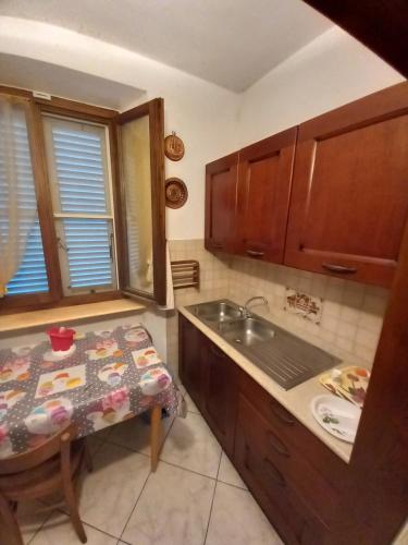 una cucina con lavandino, tavolo e bancone di Agriturismo Sant'Adriano a Venturina Terme