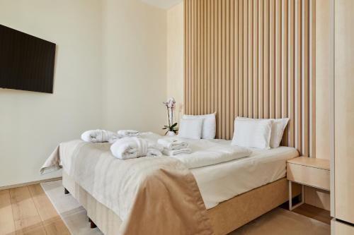 a bedroom with a large bed with towels on it at Zala Springs Golf Resort in Zalacsány