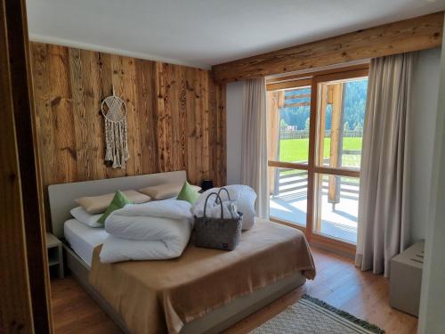 - une chambre avec un lit doté d'oreillers et d'une fenêtre dans l'établissement Exzelent Residence, à Anterselva di Mezzo