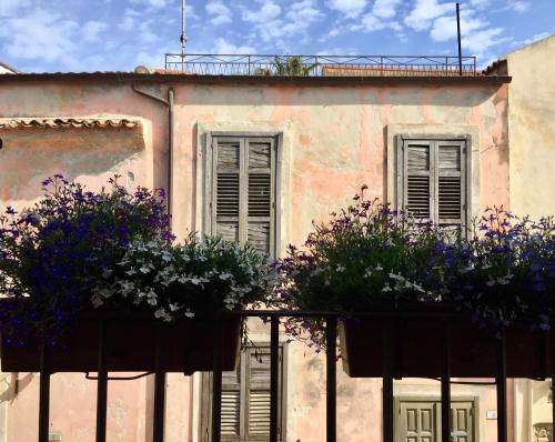 a building with windows and potted plants on a fence at Casa Rubini in Paestum