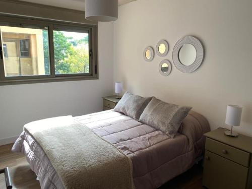 um quarto com uma cama e um espelho na parede em Excelente apto 1 dorm completo em Montevidéu