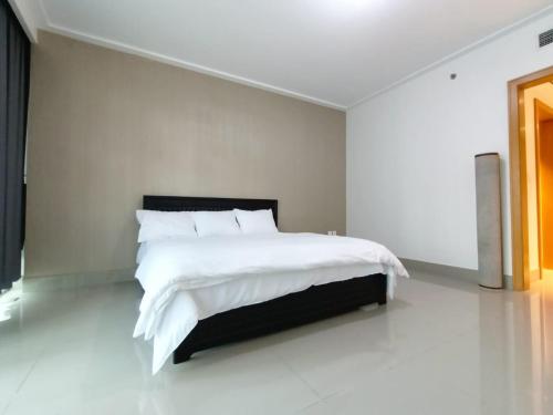 a white bedroom with a large bed with white sheets at 3 BEDROOM APARTMENT ON MONTHLY RENT in Dubai