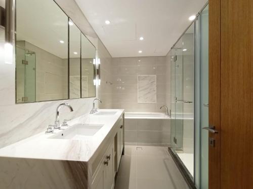 a bathroom with two sinks and a shower and a tub at 3 BEDROOM APARTMENT ON MONTHLY RENT in Dubai