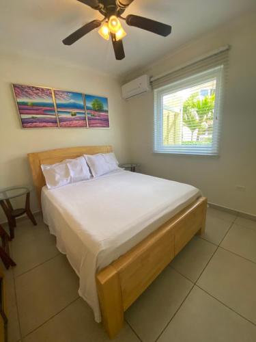 a bedroom with a bed with a ceiling fan at Pearl Aruba in Palm-Eagle Beach