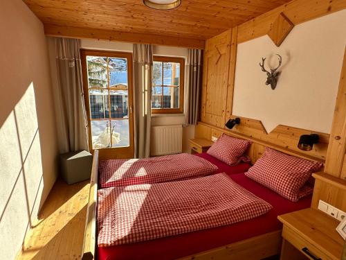um quarto com 2 camas num quarto de madeira em TiroLiving em Berwang