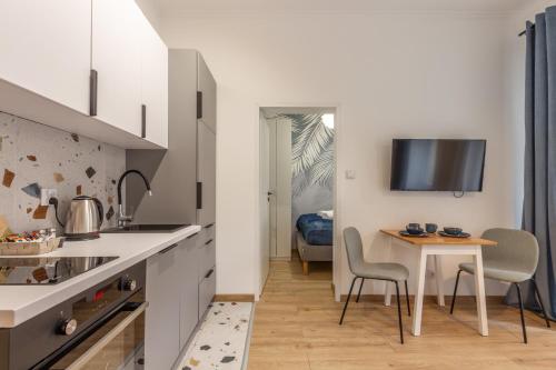 eine Küche und ein Esszimmer mit einem Tisch und Stühlen in der Unterkunft Chill Apartments Central Station Katowice in Kattowitz