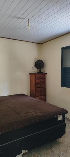 um quarto com uma cama e uma cómoda em madeira em Casa Da Rua Da Pedra em São José dos Campos