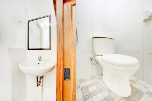 een badkamer met een toilet en een wastafel bij SUPER OYO 3702 Homestay Bougenville Syariah in Lamongan