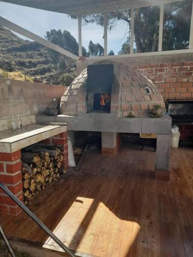un horno de ladrillo con mesa y chimenea en Casa Ymelda, en Desaguadero