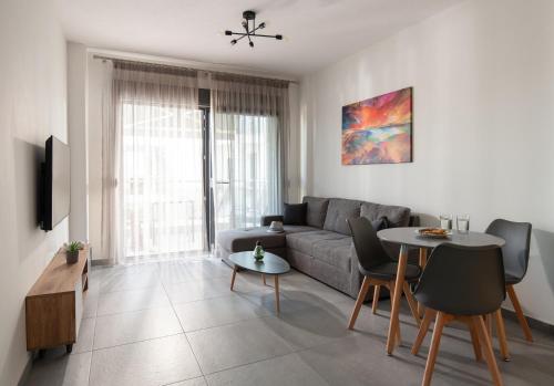 a living room with a couch and a table at The Black Pearl Villas in Kalamitsi