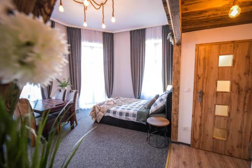 a bedroom with a bed and a table and a dining room at Willa Zator in Oświęcim