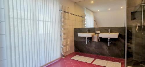 une salle de bain avec deux lavabos et une douche dans l'établissement BodenSEE Apartment Tettnang HOPFENTRAUM, à Tettnang