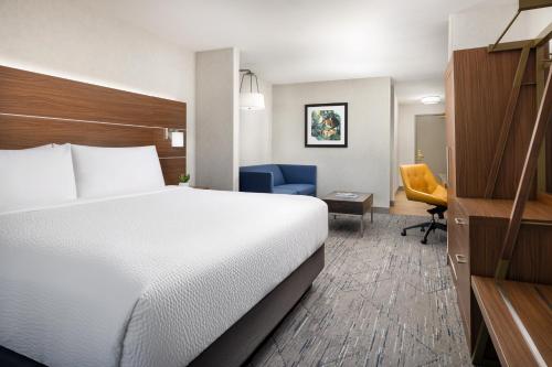 a hotel room with a bed and a chair at Holiday Inn Express Las Vegas Stadium Area by IHG in Las Vegas