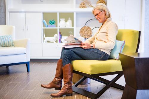 a woman sitting in a chair in a living room at Home2 Suites By Hilton Winter Garden in Orlando