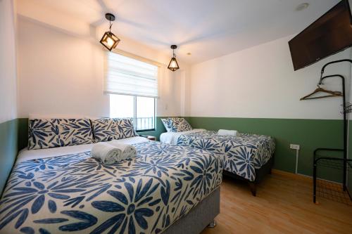 1 dormitorio con 2 camas y TV. en Casa Samaykuy en Ayacucho