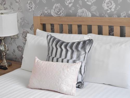 1 cama con almohadas blancas y almohada gris y blanca en The Star Hotel en Southampton