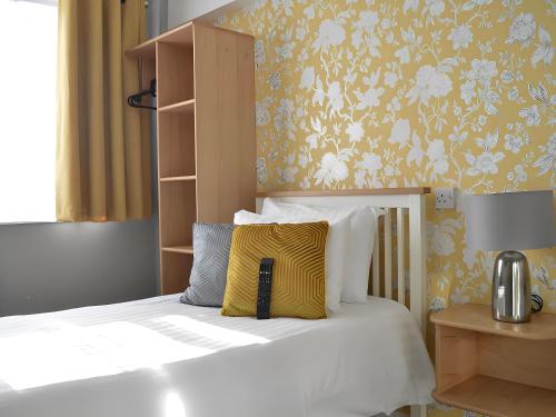 a bedroom with a bed with a yellow and white pillow at The Star Hotel in Southampton