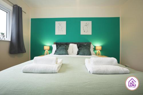 a bedroom with a large bed with a green wall at Blagdon Park, Stylish house in Bath, Free parking in Bath