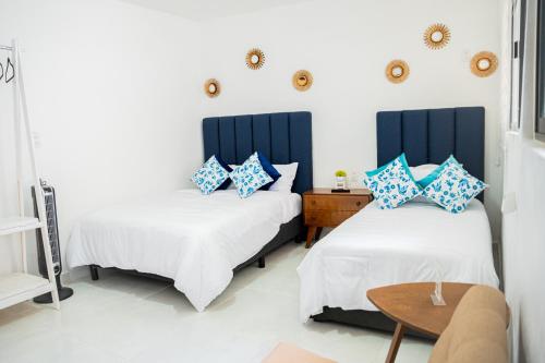 um quarto com 2 camas com almofadas azuis e brancas em Hotel Bungalows Casa Blanca em Tenancingo de Degollado