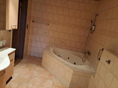 y baño con bañera y lavamanos. en Geräumige 5 Zimmerwohnung, en Peitz