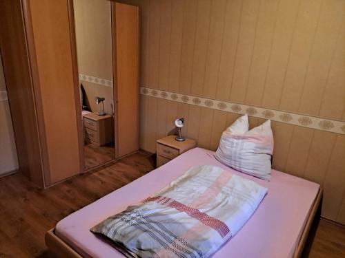 Dormitorio pequeño con cama con espejo en Geräumige 5 Zimmerwohnung, en Peitz