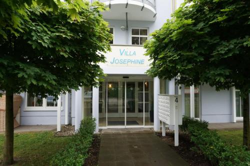 a white building with a sign in front of it at Villa Josephine App. 14 in Kühlungsborn