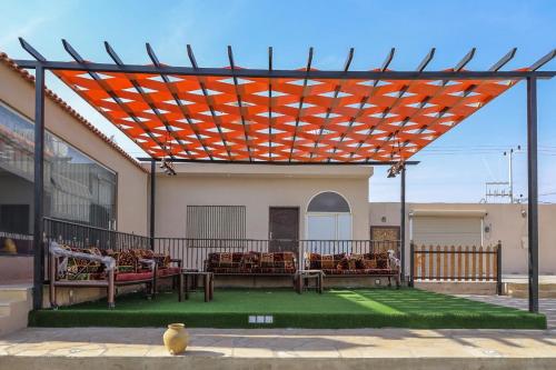 an orange pergola on a building with chairs under it at شاليه أمي لولوة in Az Zulfi
