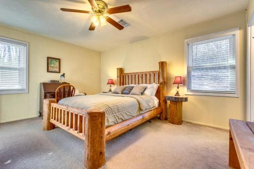 a bedroom with a wooden bed and a ceiling fan at Searcy Retreat Home Near Little Red River in Searcy