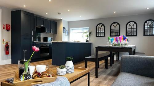a living room with a table and a kitchen at Penthouse On The Rows - Cathedral Views in Chester