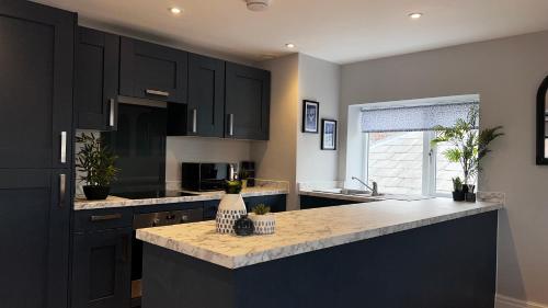 a kitchen with black cabinets and a counter top at Penthouse On The Rows - Cathedral Views in Chester