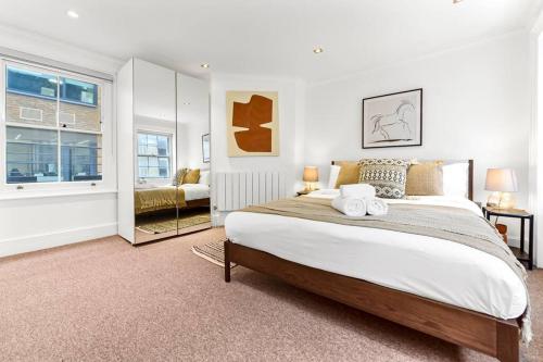 a bedroom with a large bed and a mirror at Piccadilly House in London