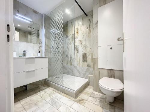 La salle de bains est pourvue d'une douche et de toilettes. dans l'établissement Deauville Studio - Face mer, à Deauville