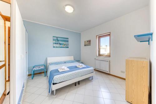 Schlafzimmer mit einem Bett und einem Fenster in der Unterkunft Appartamento climatizzato con vista mare a 50 m dalla spiaggia in Lido Marini